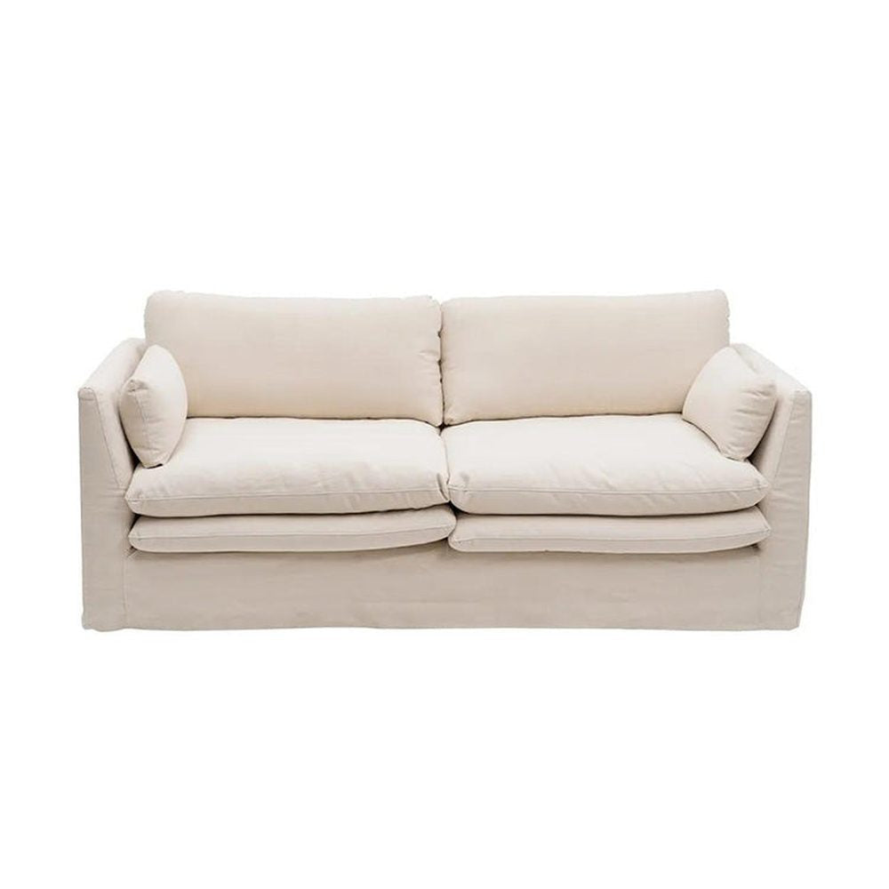 Bézs színű pamutvászon kárpitozású, kényelmes párnákkal ellátott kortárs kanapé.