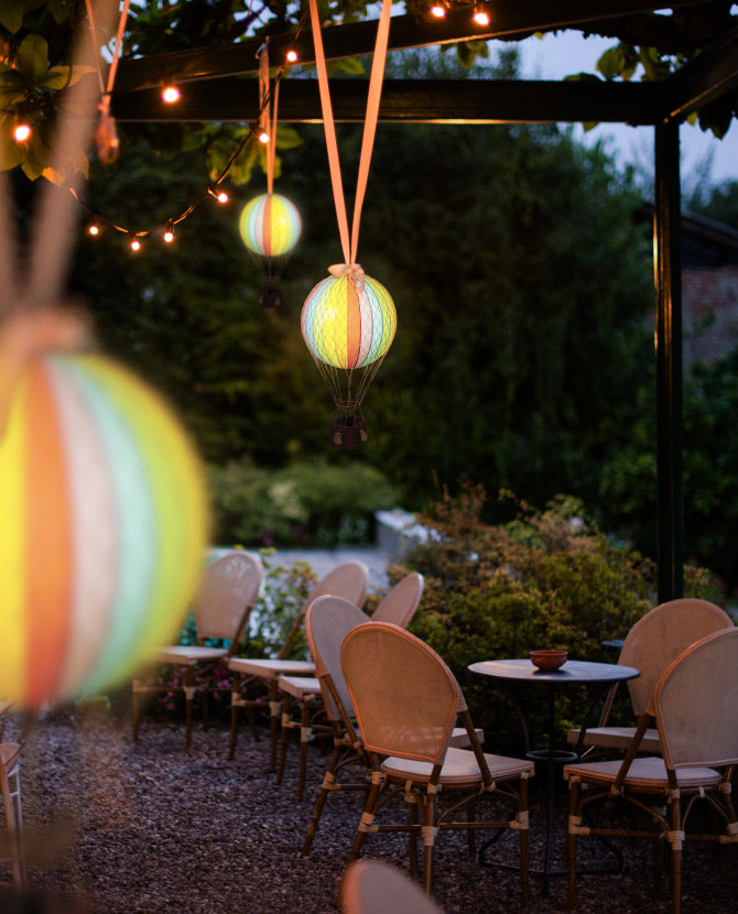 Kültéri esküvői dekorációként, pavilonra lógatott szivárványszínű LED-es hőlégballonok.