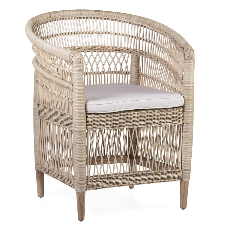 Natural rattan armchair from the Tribe collection with a curved back and a light cushion