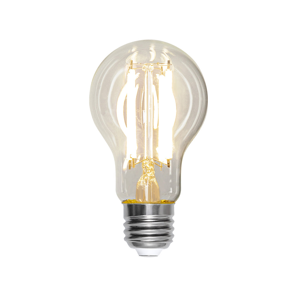 Tiszta üvegű, melegfehér fényű LED izzó E27-es foglalattal, A60-as formával, 4 szálas filament kialakítással, világítás közben.