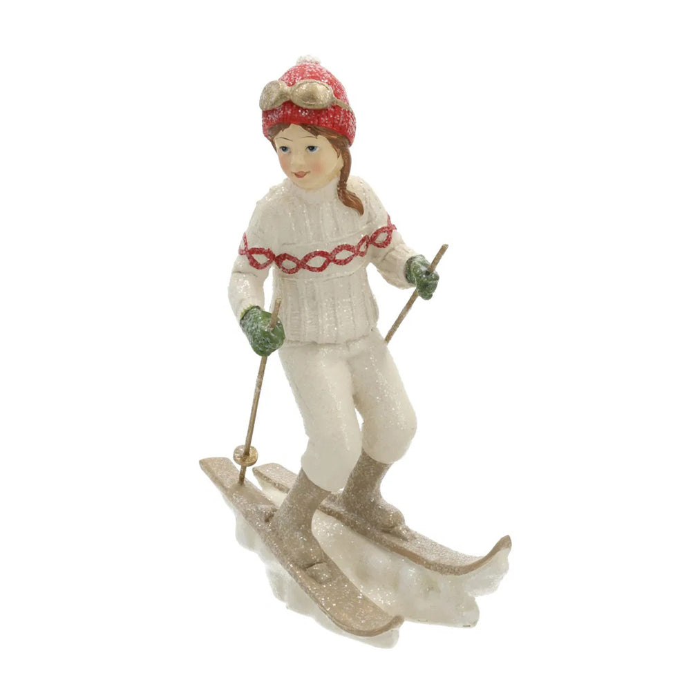 Heritage fehér karácsonyi síelő kislány figura elölnézetből, piros sapkában és síléceken