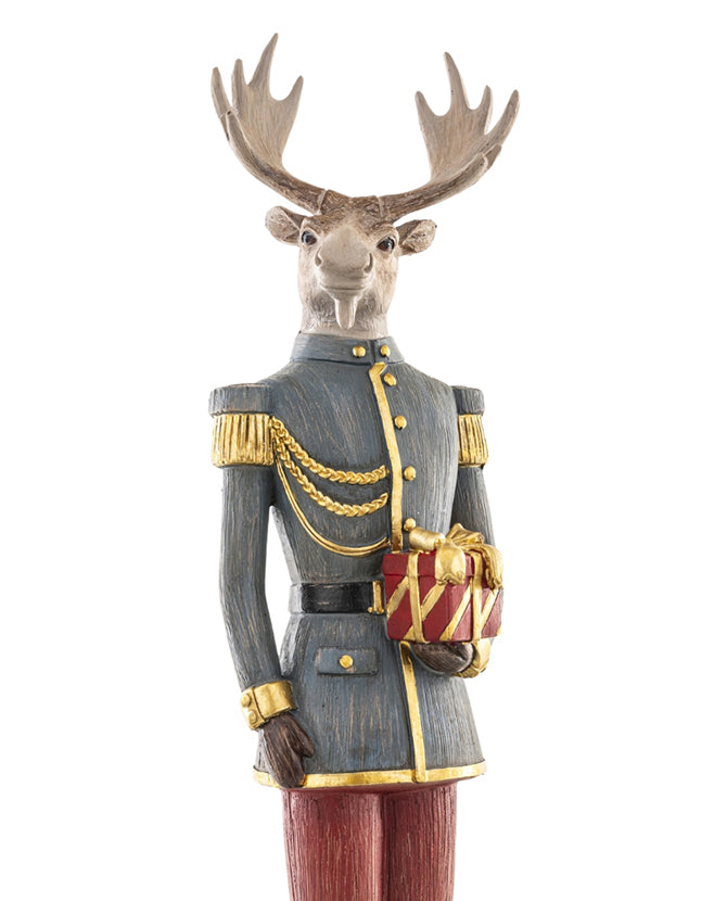 Tábornoki ruhába öltözött, ajándékot tartó karácsonyi szarvas figura.