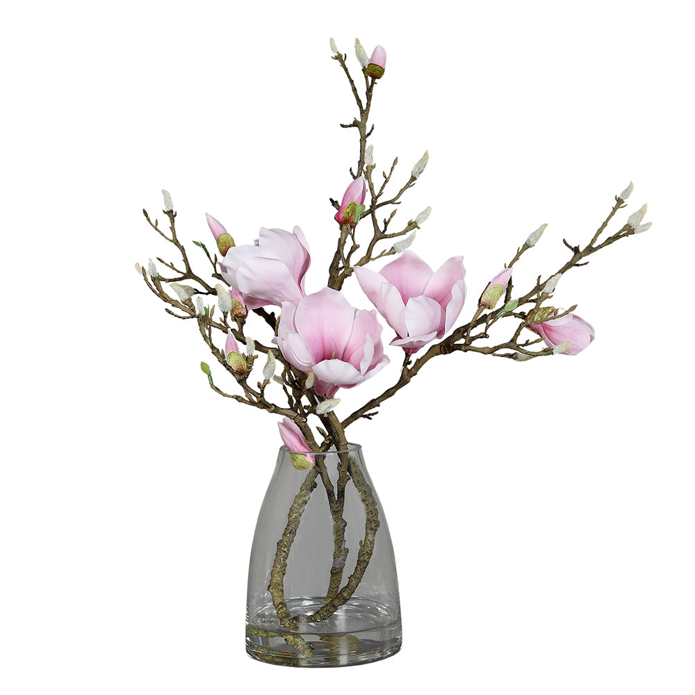 Halvány rózsaszín színű, mű magnólia kompozíció, modern formájú üvegvázában..