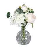 Krémszínű, vegyes művirágokból készült virágcsokor üvegvázában..