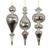 Három darab különböző formájú, ezüst színű üveg jégcsap karácsonyfadísz fehér háttéren.