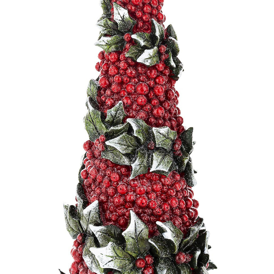 A dekor fenyőkúp piros bogyómotívumainak és erezett zöld magyalleveleinek közeli részlete, fehér havas díszítéssel.