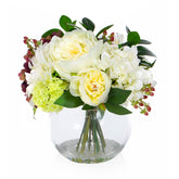 Mű hortenziákból és bazsarózsákból készült nagy virágcsokor, áttetsző üvegvázában.