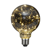 Decoled meleg fehér fényű LED dekorációs izzó füstszínű üveggel, melynek belsejében egy 25 égős fényfüzér került elhelyezésre.