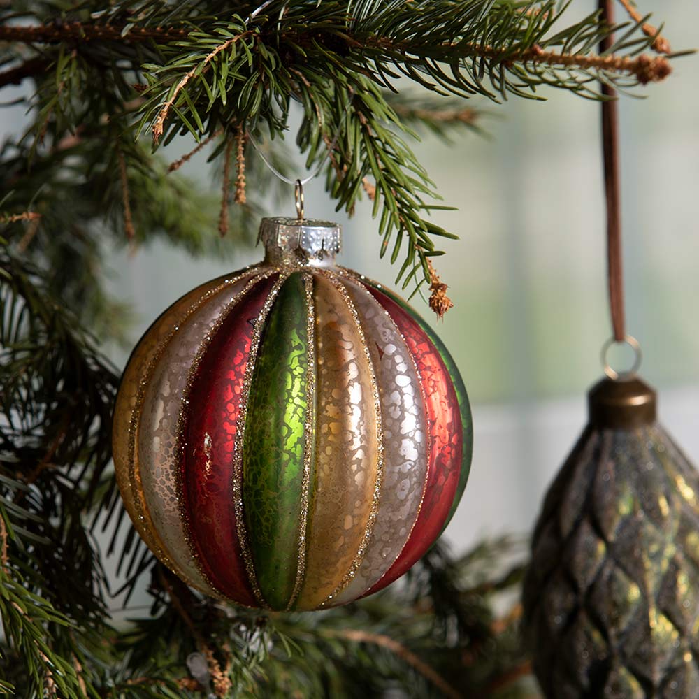 Retró- vintage stílusú, bordázott üvegű, bordó, zöld és aranyszínű üveg karácsonyfadísz fenyőágon.  