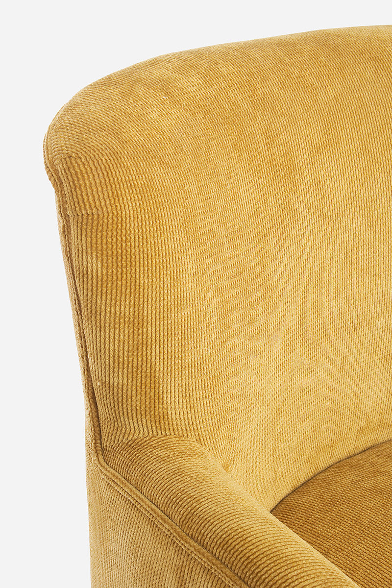 A retró stílusú, okkersárga színű fotel háttámla és karfa részlete.