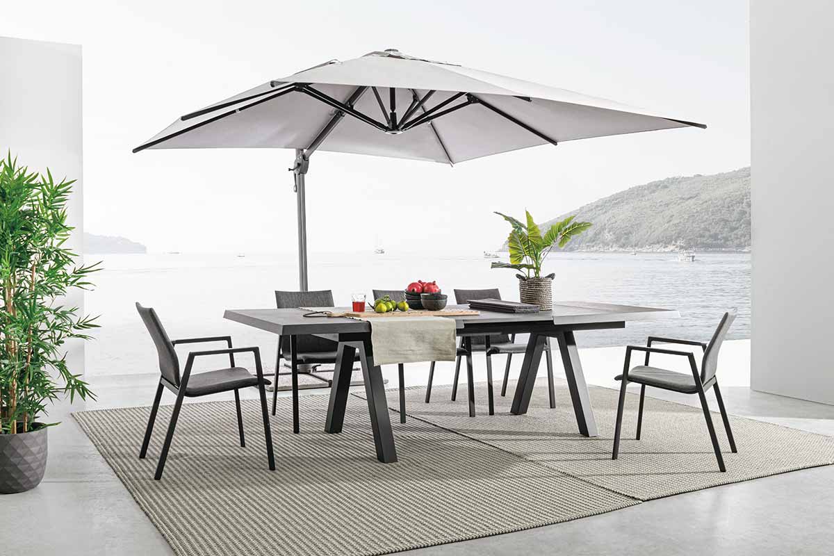 Modern stílusú teraszon álló kerti garnitúra és fémvázas napernyő.