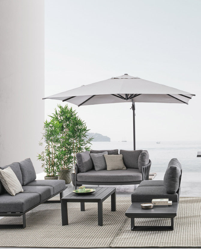 Modern stílusú teraszon álló kerti garnitúra és fémvázas napernyő.