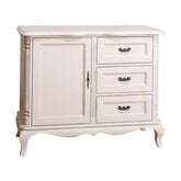 Fehér színű, shabby chic stílusú fenyőfa komód három fiókkal és egy ajtós tárolóval.