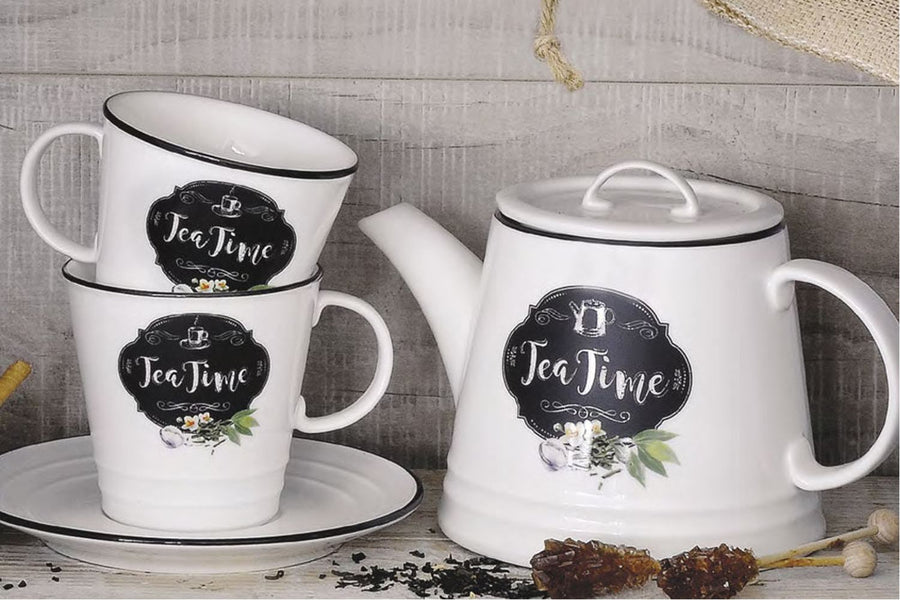 Fehér színű porcelán teáskanna és bögre tea time felirattal szürke deszkafal előtt