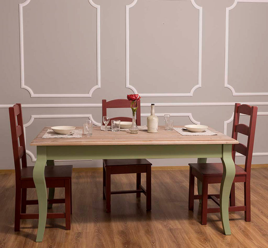 160 cm solid pine dining table with curved legs in rustic country style from the Maison collection, shown with chairs.