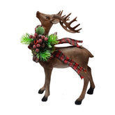 Karácsonyi fenyődísszel, piros bogyóval és masnival díszített szarvas figura