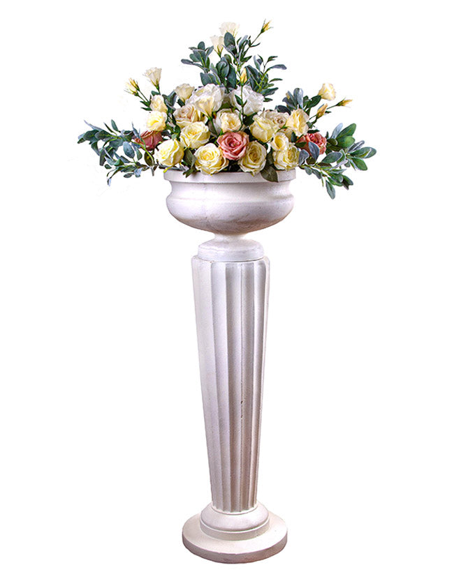 Óriás méretű, sima felületű, fehér színű talpas kaspó kannelúrás posztamensen virágokkal