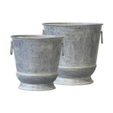 Antikolt felületű bádogból készült, nagyméretű, 31 és 36,5 cm átmérőjű, vidéki vintage stílusú, szürke színű kaspó szett.