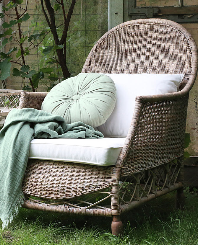 Prémium kategóriás, vintage stílusú, termesztés rattanból készült fonott kerti fotel pamut párnával, zöld kerti térben