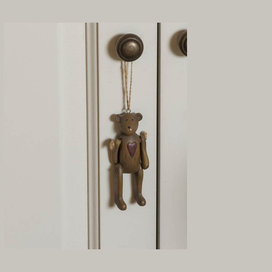 Vintage stílusú, 10 cm magas, függeszthető kialakítású, barna színű, fa hatású maci figura.