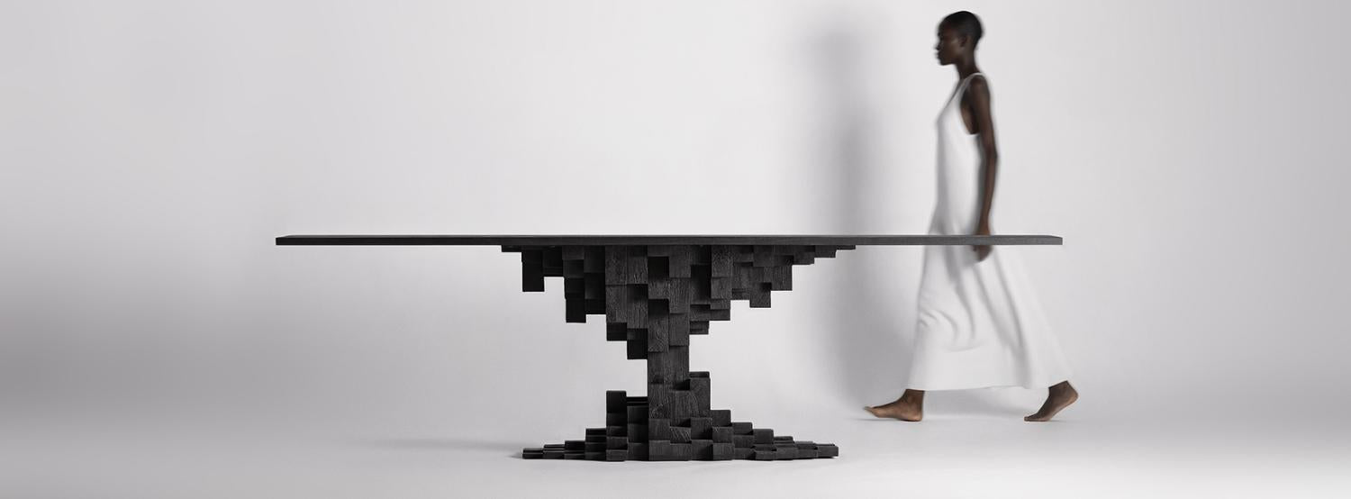 Kortárs stílusú designer étkezőszék szoborszerű fekete étkezőasztallal minimalista enteriőrben.