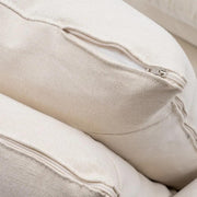 Bézs színű pamutvászon kárpitozású, kényelmes párnákkal ellátott kortárs kanapé..