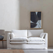 Bézs színű pamutvászon kárpitozású, kényelmes párnákkal ellátott kortárs kanapé..