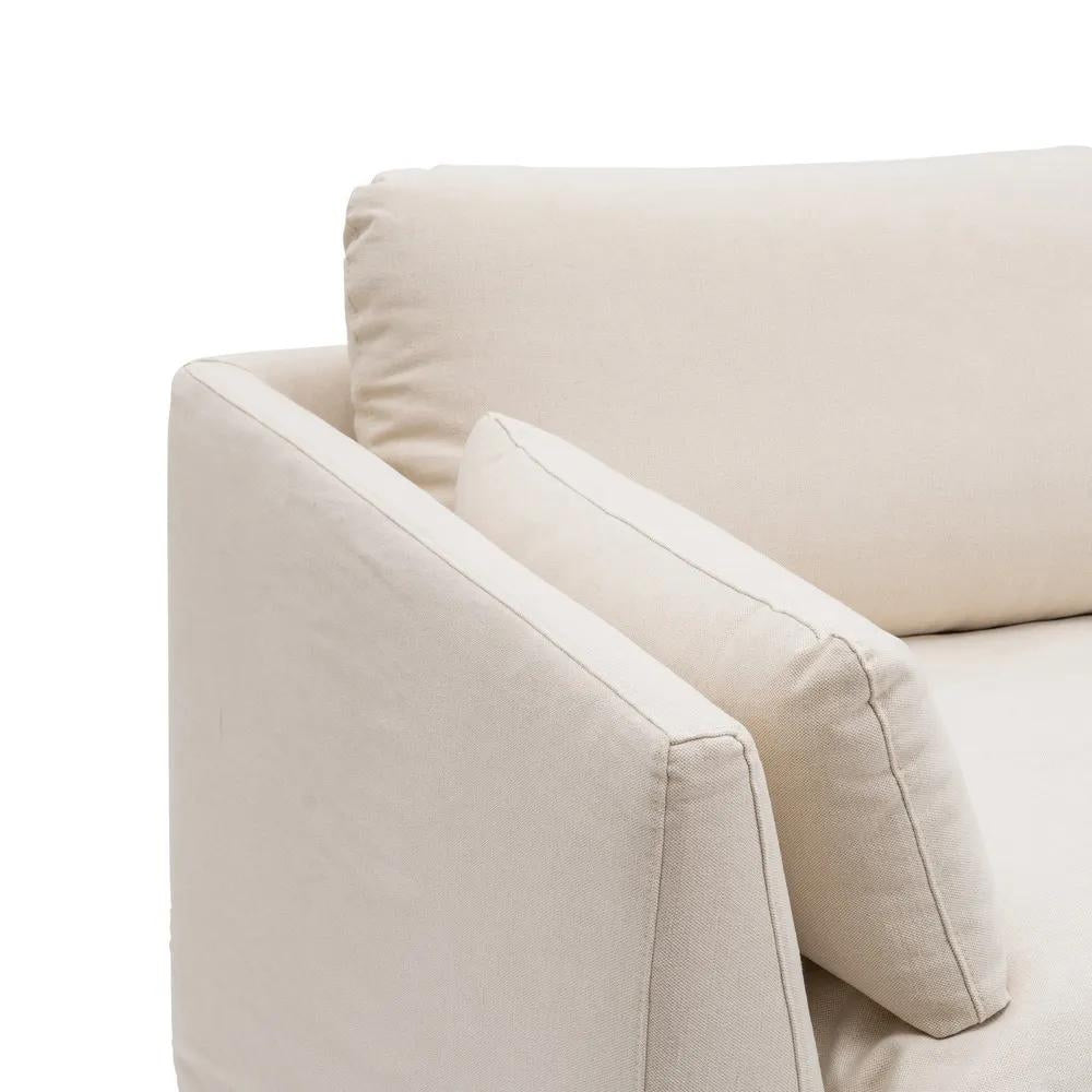 Bézs színű pamutvászon kárpitozású, kényelmes párnákkal ellátott kortárs kanapé..