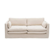 Bézs színű pamutvászon kárpitozású, kényelmes párnákkal ellátott kortárs kanapé.