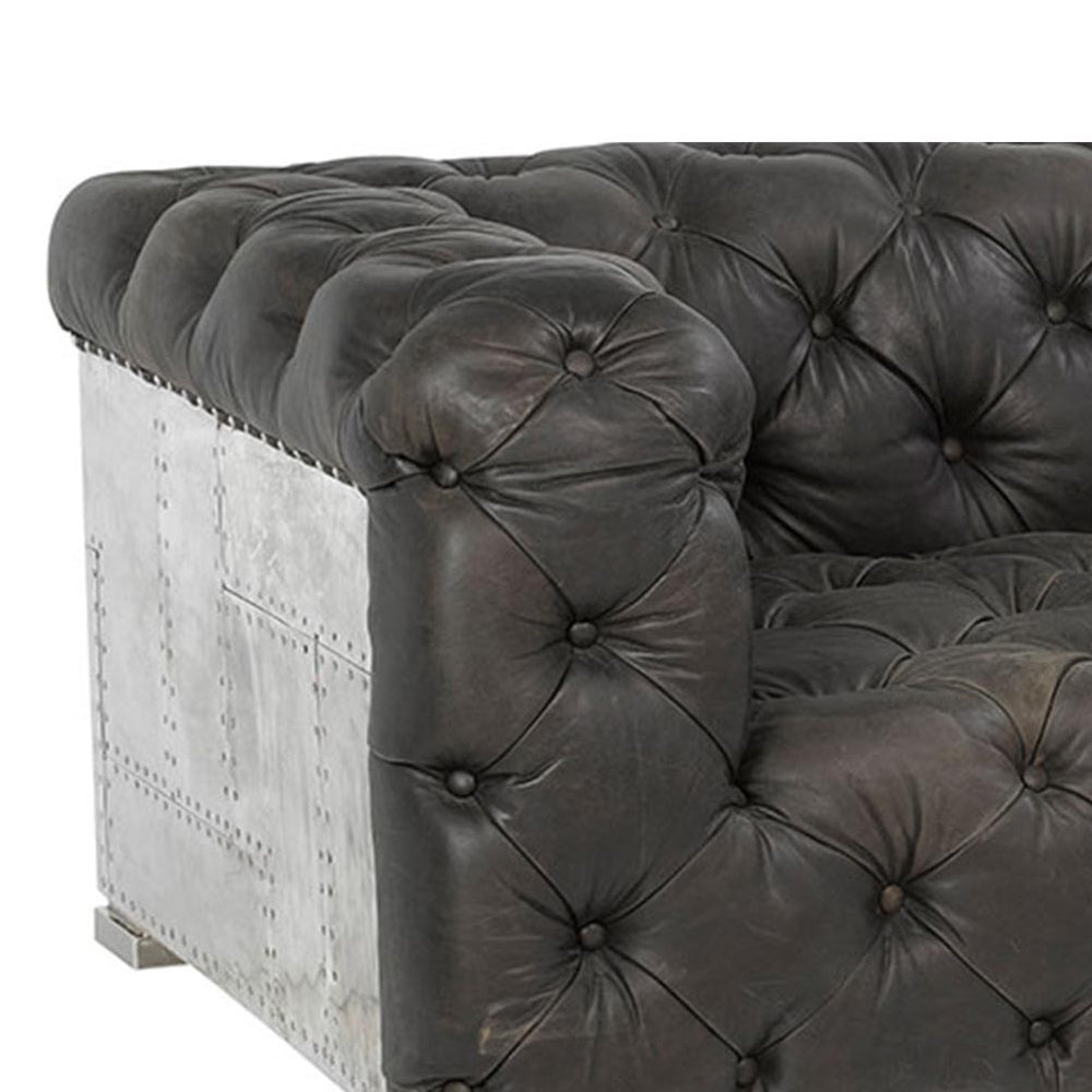 Szegecselt alumínium lemez borítású, montaigne fekete színű kecskebőrrel kárpitozott design kanapé.
