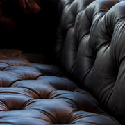 Szegecselt alumínium lemez borítású, montaigne fekete színű kecskebőrrel kárpitozott design kanapé.