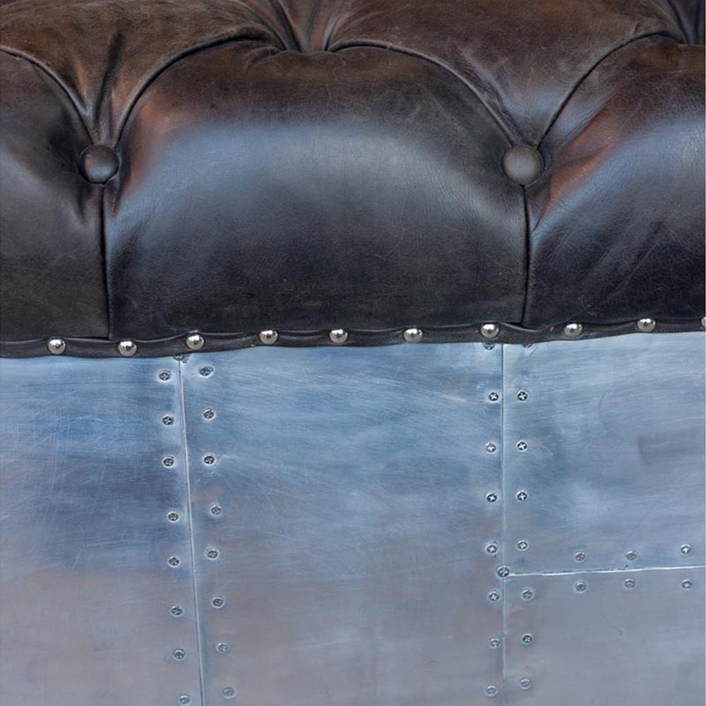 Szegecselt alumínium lemez borítású, montaigne fekete színű kecskebőrrel kárpitozott design kanapé.