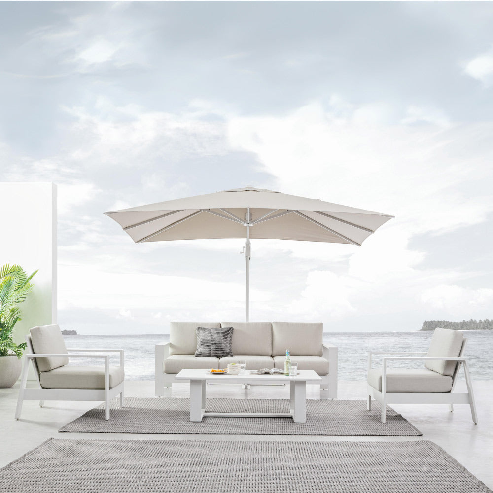 Kortárs stílusú, fehér színű kerti ülőgarnitúra napernyővel tengerparti teraszon.