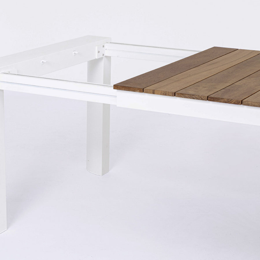 Óriás méretű, bővíthető, fehér színű alumínium étkezőasztal natúr színű teakfa fedlappal.