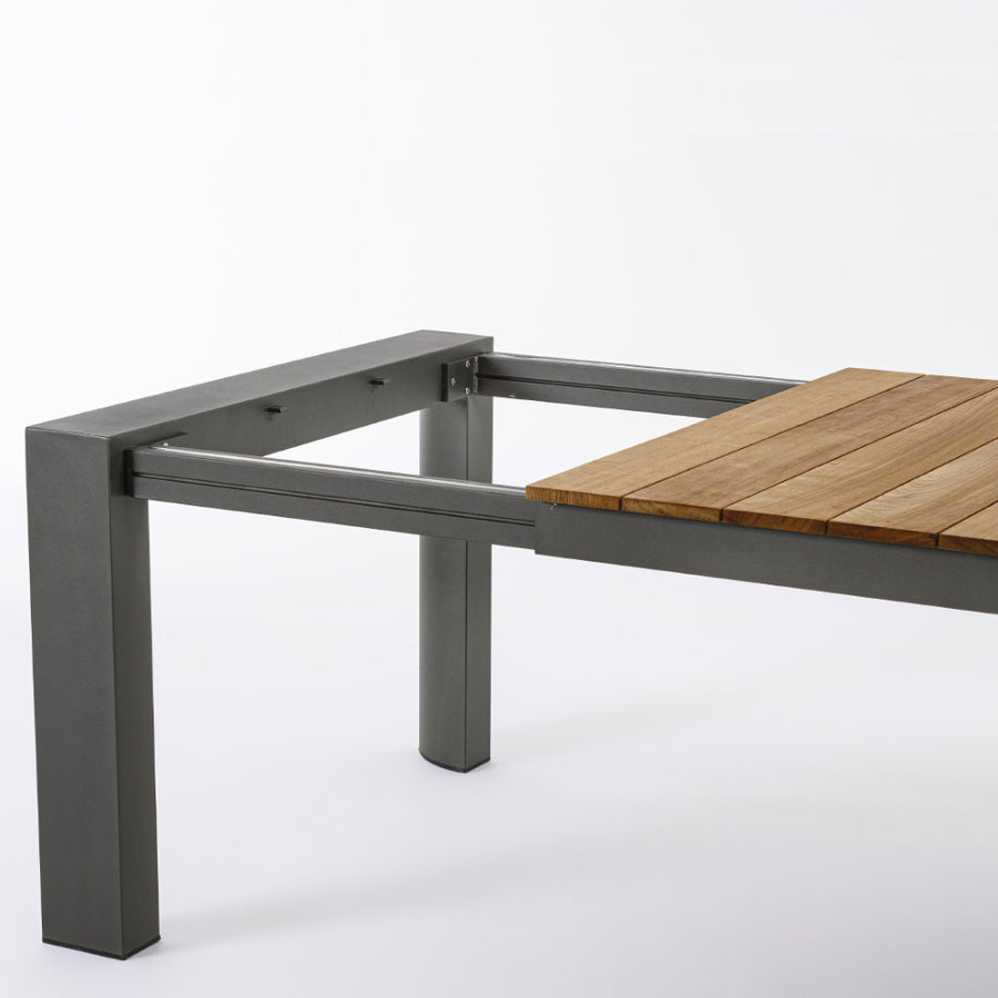 Óriás méretű, bővíthető, sötétszürke színű alumínium étkezőasztal natúr színű teakfa fedlappal.