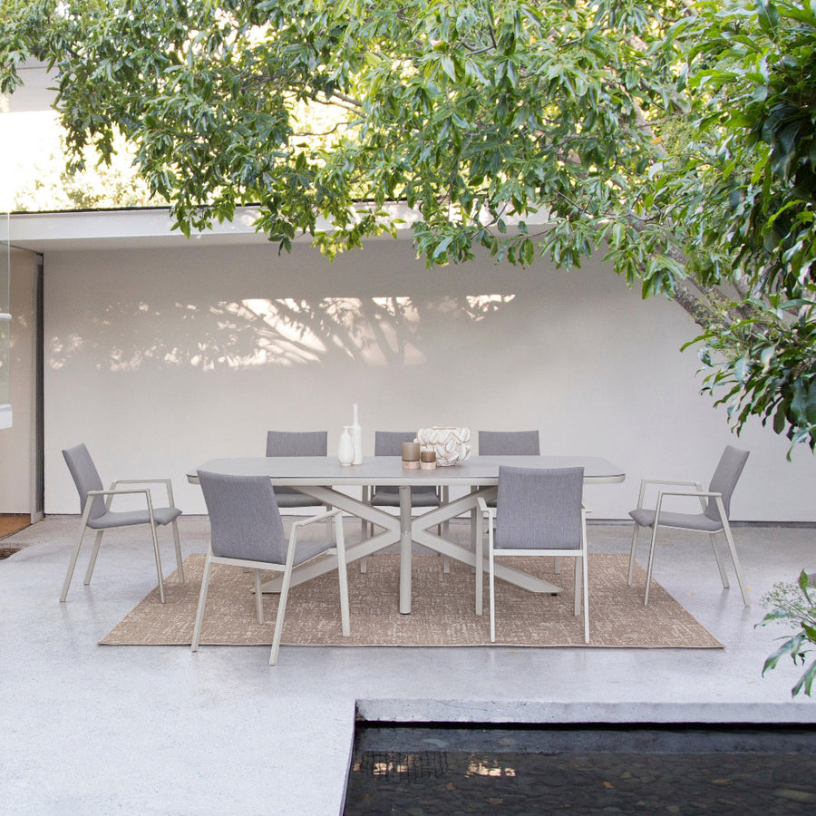 Kortárs, bézs színű, alumíniumvázzal rendelkező kültéri étkezőasztal szinterezett kő fedlappal.