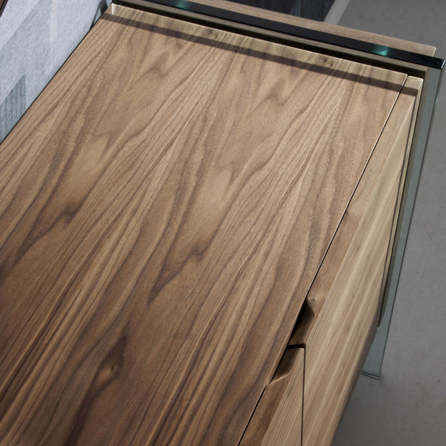 Kortárs, diófa furnérral borított, dizájn komódszekrény edzett üveg lábakkal.