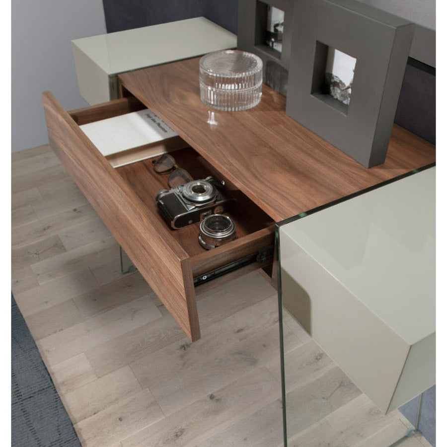 Kortárs stílusú, diófa furnérral borított, dizájn konzolasztal edzett üveg lábakkal.