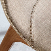 Bézs színű szövettel kárpitozott, kőrisfából készült étkezőszék.