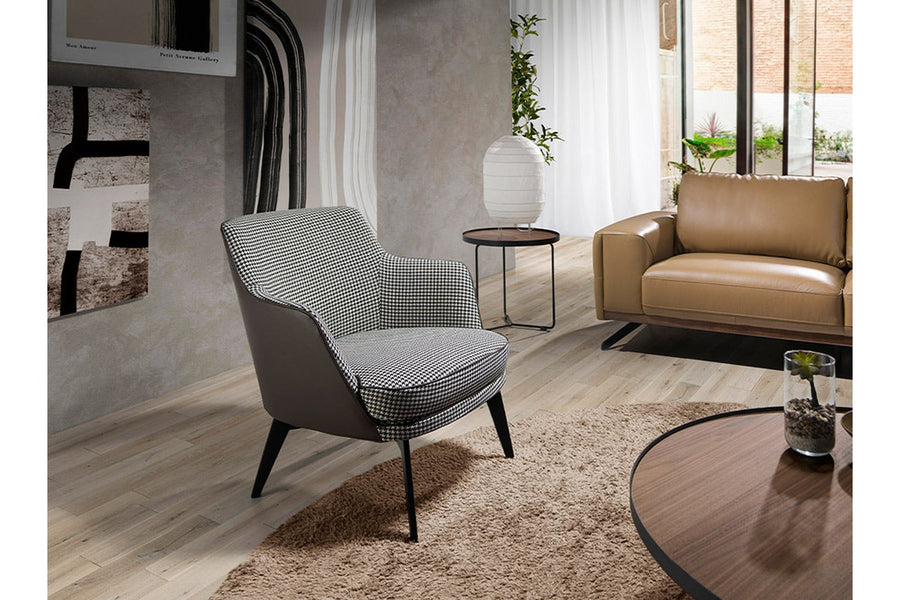 Kortárs stílusú, fekete színű műbőrrel és pepita színű szövettel kárpitozott dizájn fotel.