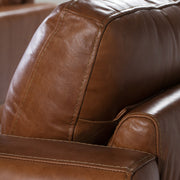 Kortárs stílusú, dohánybarna bőrrel kárpitozott, dizájn fotel diófa lábakkal.