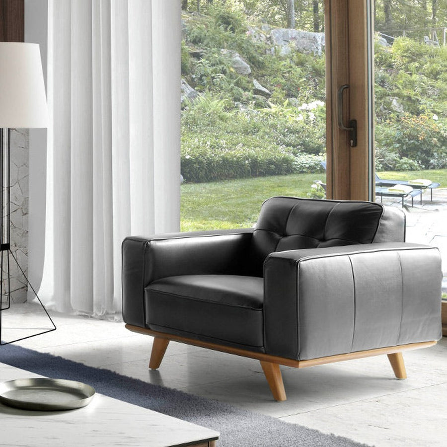 Kortárs stílusú, fekete bőrrel kárpitozott, dizájn fotel diófa lábakkal.