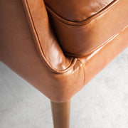 Kortárs stílusú, whiskey-barna bőrrel kárpitozott, dizájn fotel, kőrisfa lábakkal