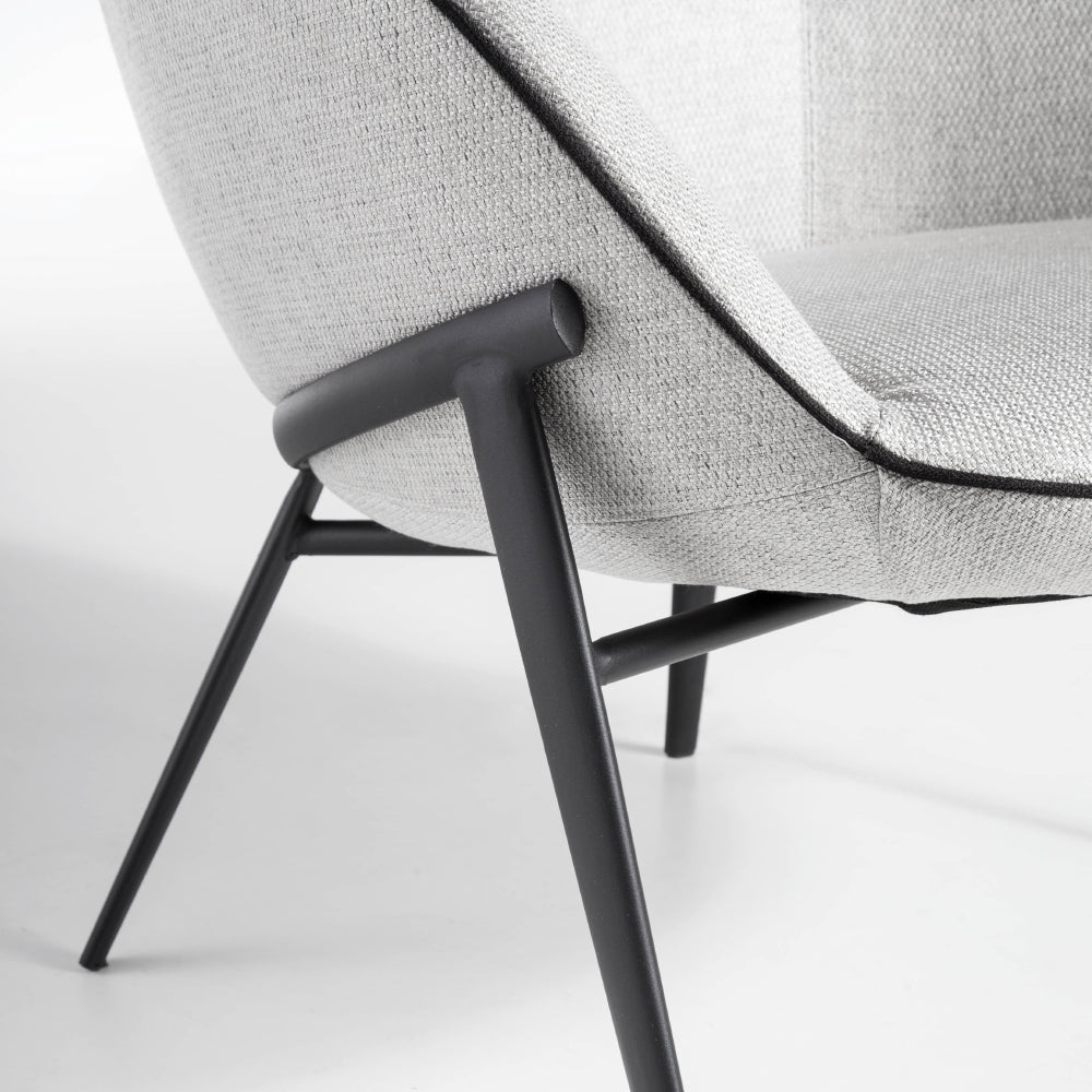 Kortárs stílusú, szürke színű szövettel kárpitozott, acélszerkezetű dizájn fotel.