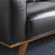 Kortárs stílusú, fekete színű bőrrel kárpitozott, fenyőfaszerkezetes, dizájn kanapé.