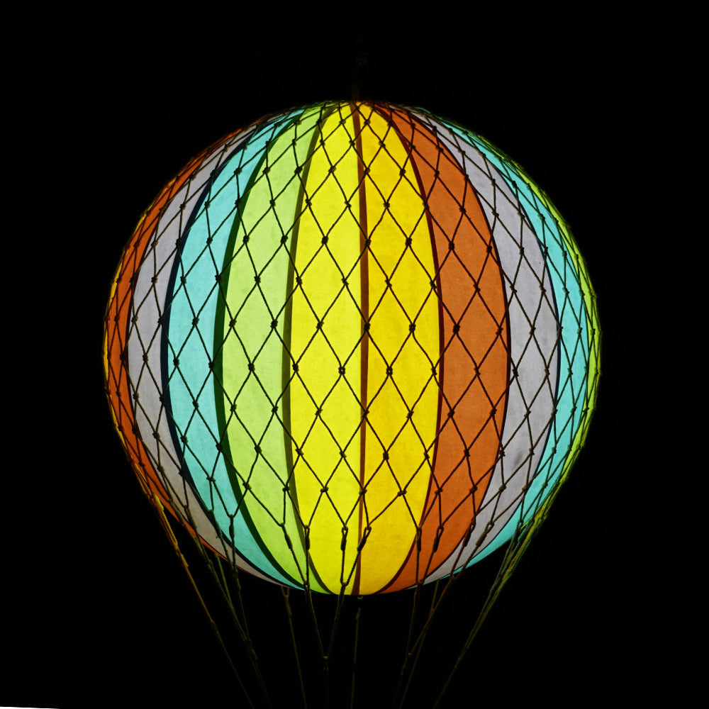A szivárványszínű LED-es hőlégballon sötétben.