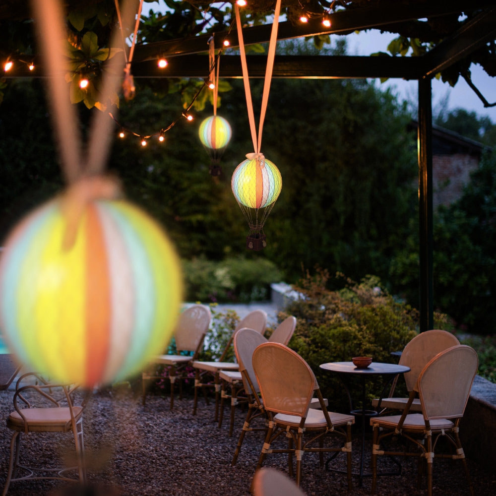 Kültéri esküvői dekorációként, pavilonra lógatott szivárványszínű LED-es hőlégballonok.
