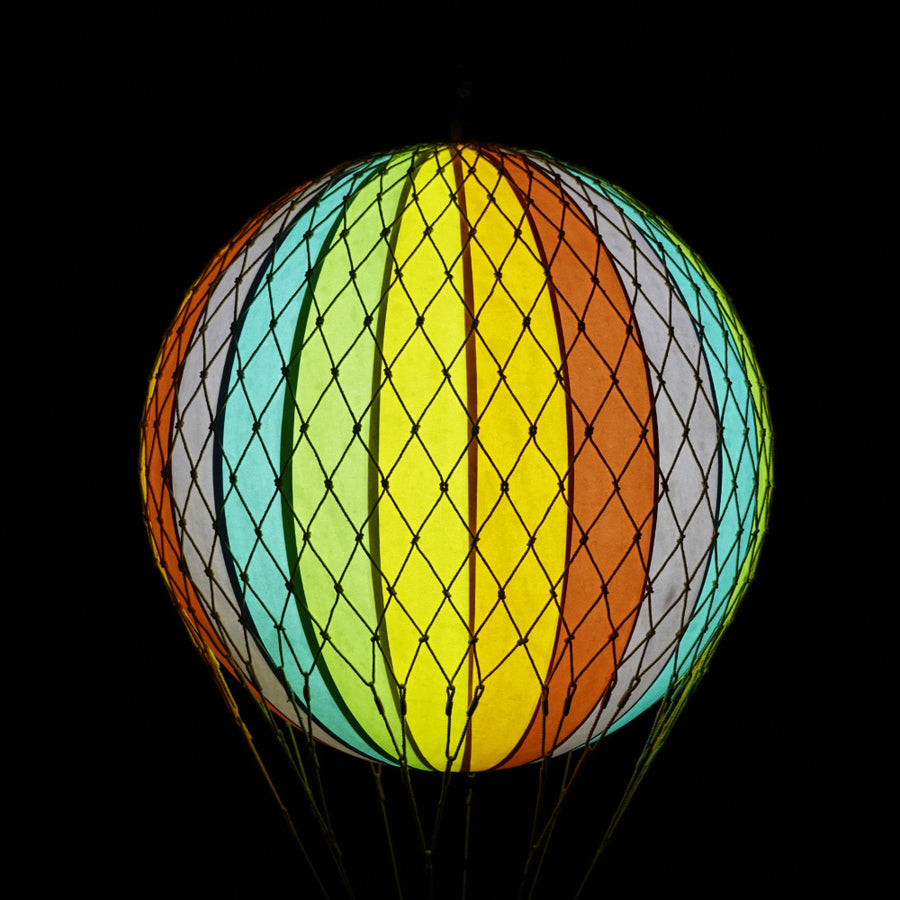 A szivárványszínű LED-es hőlégballon sötétben.