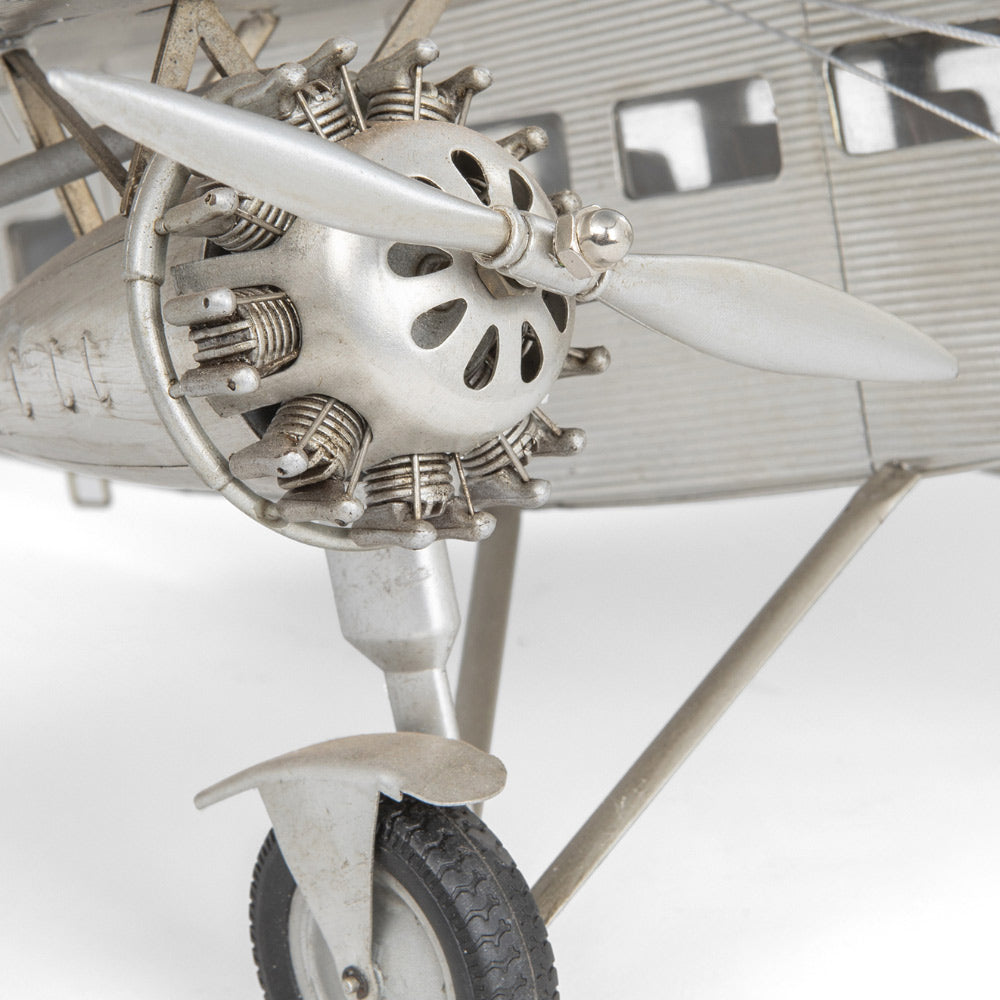 Fémből készült, részletgazdag, ezüstszínű Ford Trimotor repülőgép-modell állványon