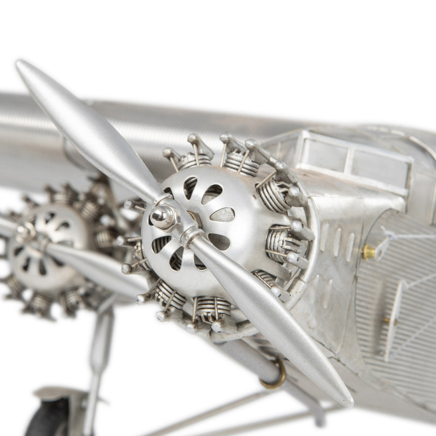 Fémből készült, részletgazdag, ezüstszínű Ford Trimotor repülőgép-modell állványon